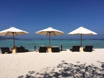 Lifeguard hut on beach against clear blue sky