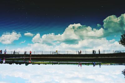 People by water against sky