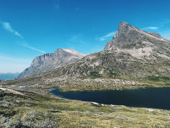 Scenic view of high mountains against blue sky and lake with copyspace and sunlight 