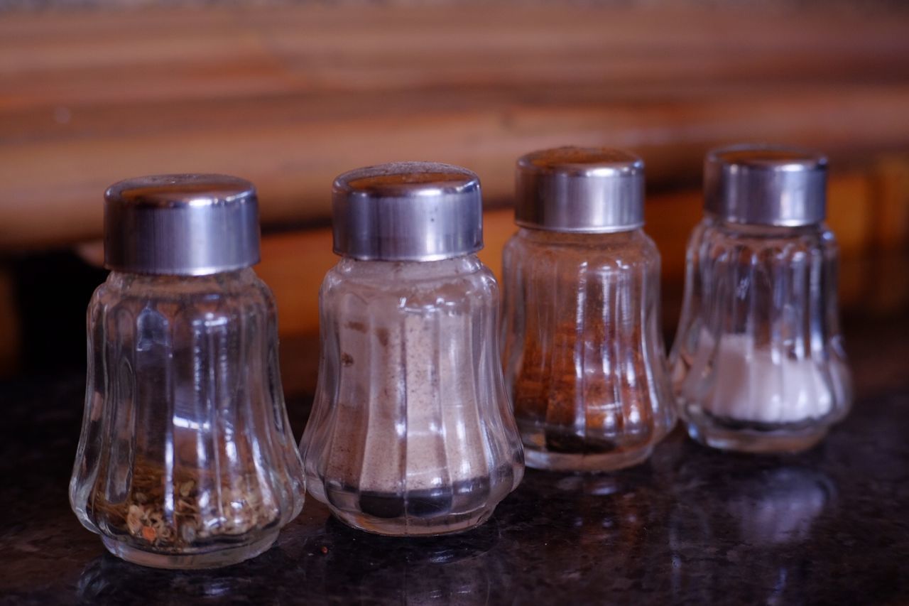 table, glass - material, indoors, no people, transparent, close-up, still life, wood - material, in a row, focus on foreground, household equipment, arrangement, glass, group of objects, drinking glass, side by side, empty, brown, choice, reflection