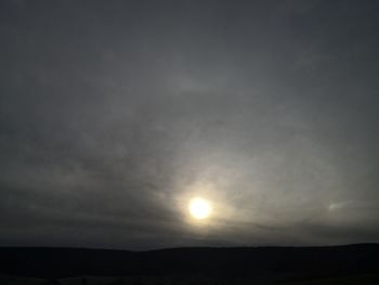 Silhouette of landscape against cloudy sky