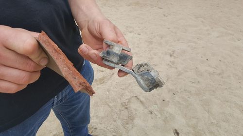 Midsection of man holding ice cream on beach