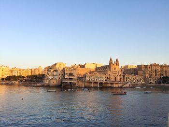 View of buildings at waterfront against clear sky