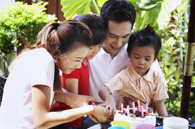 Family celebrating birthday in lawn