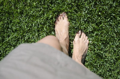 Low section of woman standing on green grass