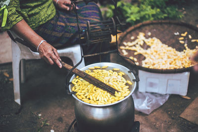 Midsection of person preparing food on barbecue grill