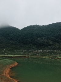Scenic view of lake and mountains against sky