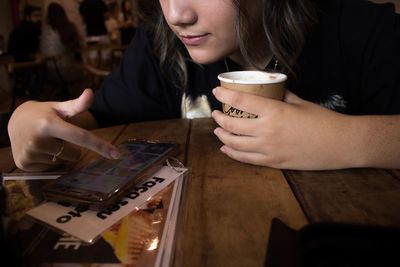 Midsection of woman drinking coffee