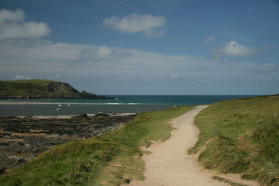 View of footpath on calm sea against the sky