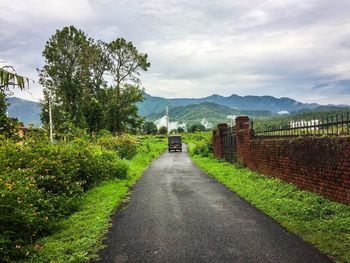 Road amidst trees against sky