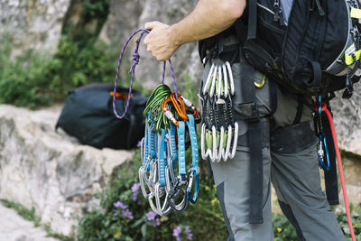 Man holding climbing harness outdoors