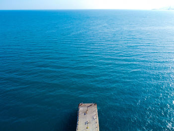 Pier and sea at sunny afternoon aerial view.