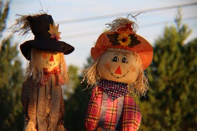 Close-up of scarecrows against sky