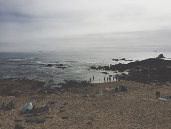 People at beach against sky