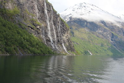 Scenic view of lake by mountain against sky