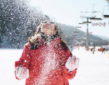 Woman standing by falling snow