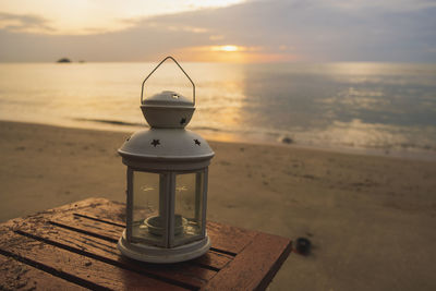 Lifeguard hut on beach against sky during sunset