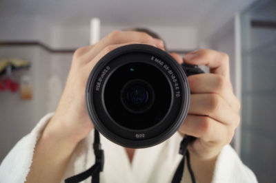 Close-up of person holding dslr in bathroom