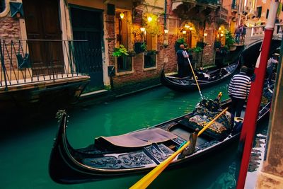 Boats moored in canal against buildings in city