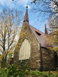 Low angle view of building and trees against sky
