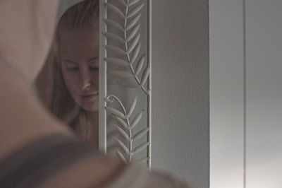 Close-up of woman with reflection on mirror at home