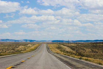 Country road against cloudy sky