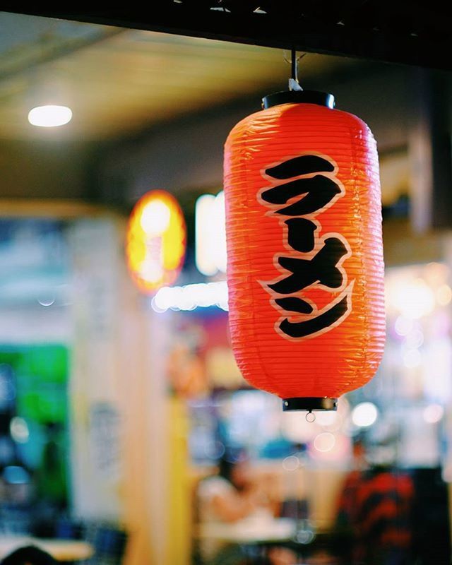 focus on foreground, indoors, red, close-up, hanging, illuminated, text, communication, decoration, western script, lantern, tradition, human representation, celebration, lighting equipment, cultures, selective focus, night, no people, non-western script