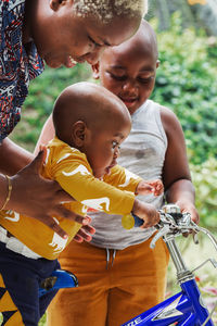 Father and son holding baby outdoors