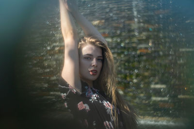 Portrait of young woman against wall