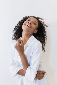 Happy young woman with head back against white background