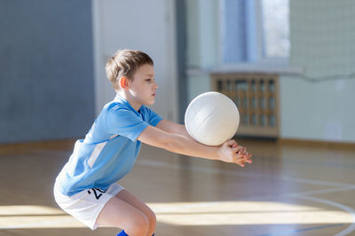 Side view of boy playing volleyball