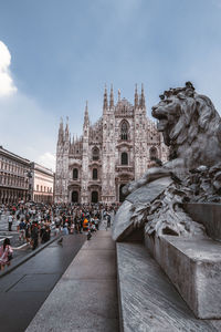 Group of people in front of historic building against sky