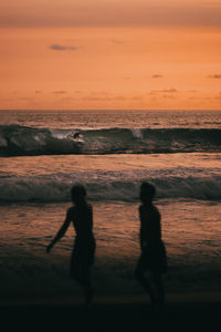 Silhouette people on beach during sunset