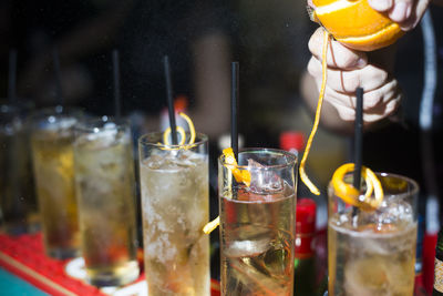 Cropped image of person garnishing cocktail glasses in bar