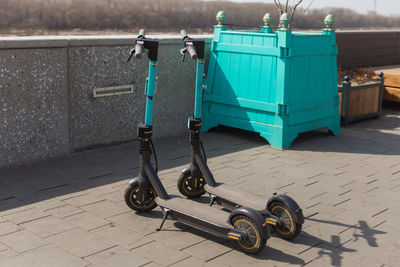 Low section of man riding push scooter on street