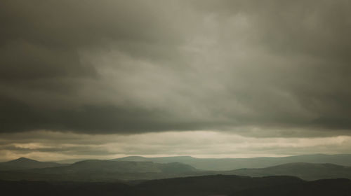 Scenic view of mountains against cloudy sky