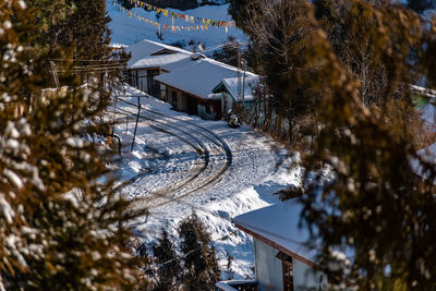 High angle view of snow covered houses by trees