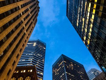 Low angle view of modern buildings against blue sky