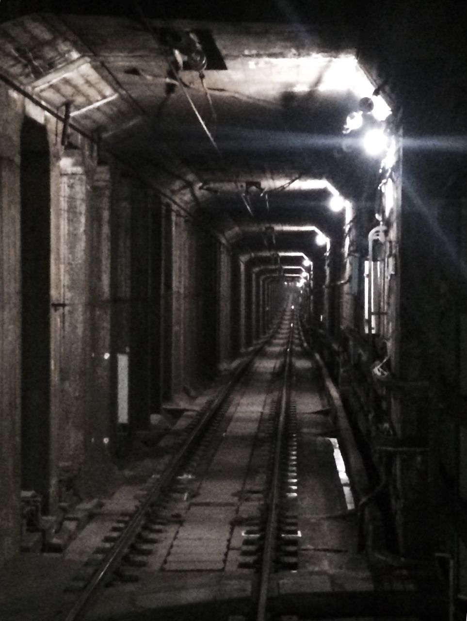 indoors, the way forward, diminishing perspective, illuminated, transportation, vanishing point, tunnel, ceiling, architecture, built structure, empty, lighting equipment, subway, railroad track, rail transportation, absence, long, underground, corridor, railroad station