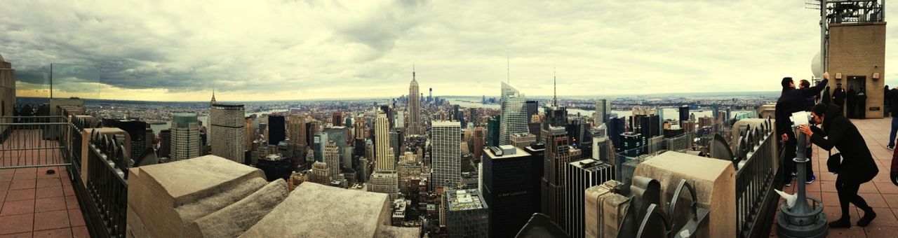 building exterior, architecture, cityscape, sky, built structure, city, cloud - sky, crowded, residential district, tower, cloud, water, high angle view, city life, panoramic, cloudy, skyscraper, sea, travel destinations, residential building