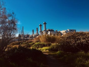 View of factory against clear blue sky