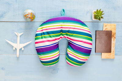 Directly above shot of neck pillow with book and model airplane on table