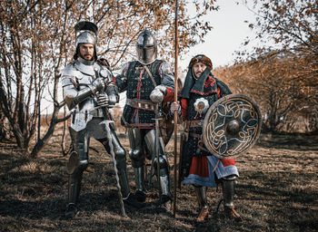 Portrait of warriors standing against trees