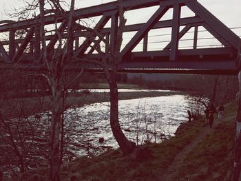 Metal bridge over water against sky