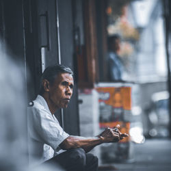 Side view of man looking at window