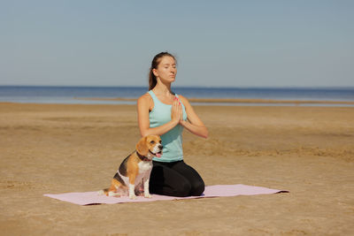 Side view of woman with dog on beach