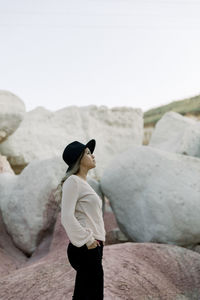 Side view of woman standing on rock