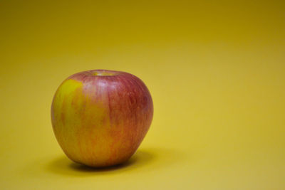 Close-up of apple against yellow background