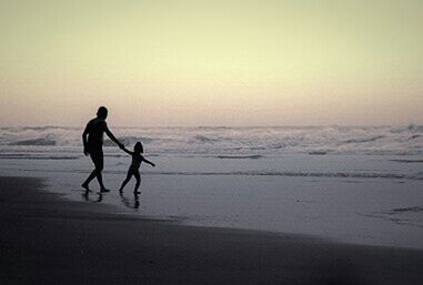 Woman standing on beach at sunset