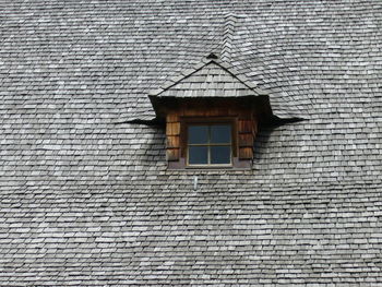 Low angle view of window and wooden roof tiles